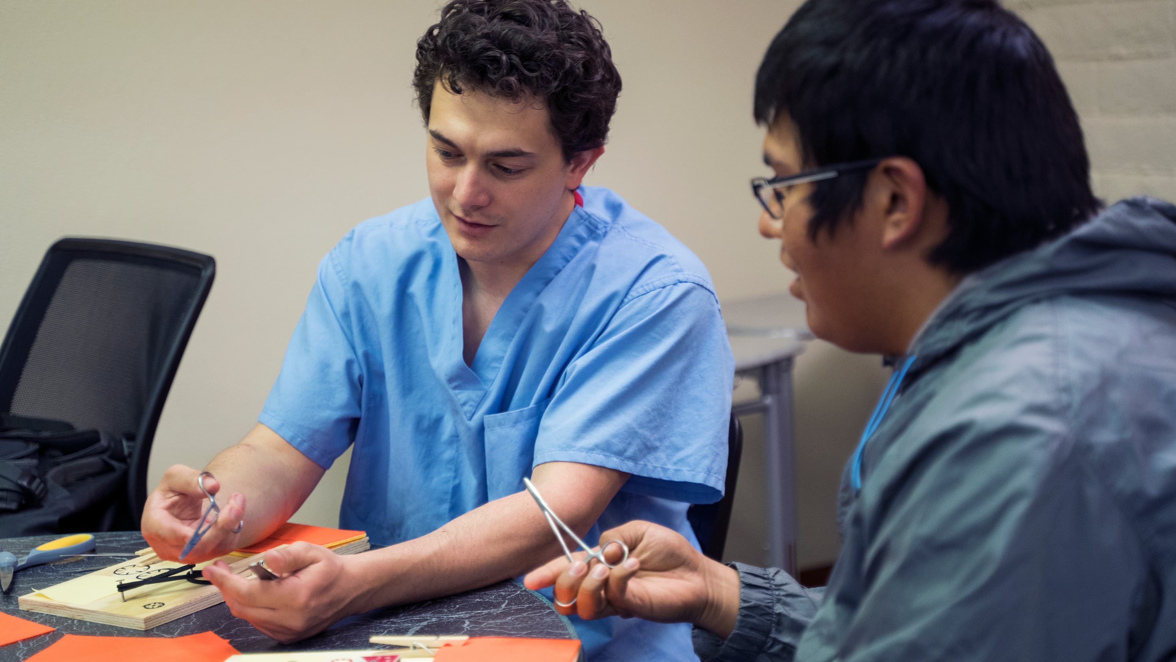 Instructor holding a suture needle driver during a workshop demonstration