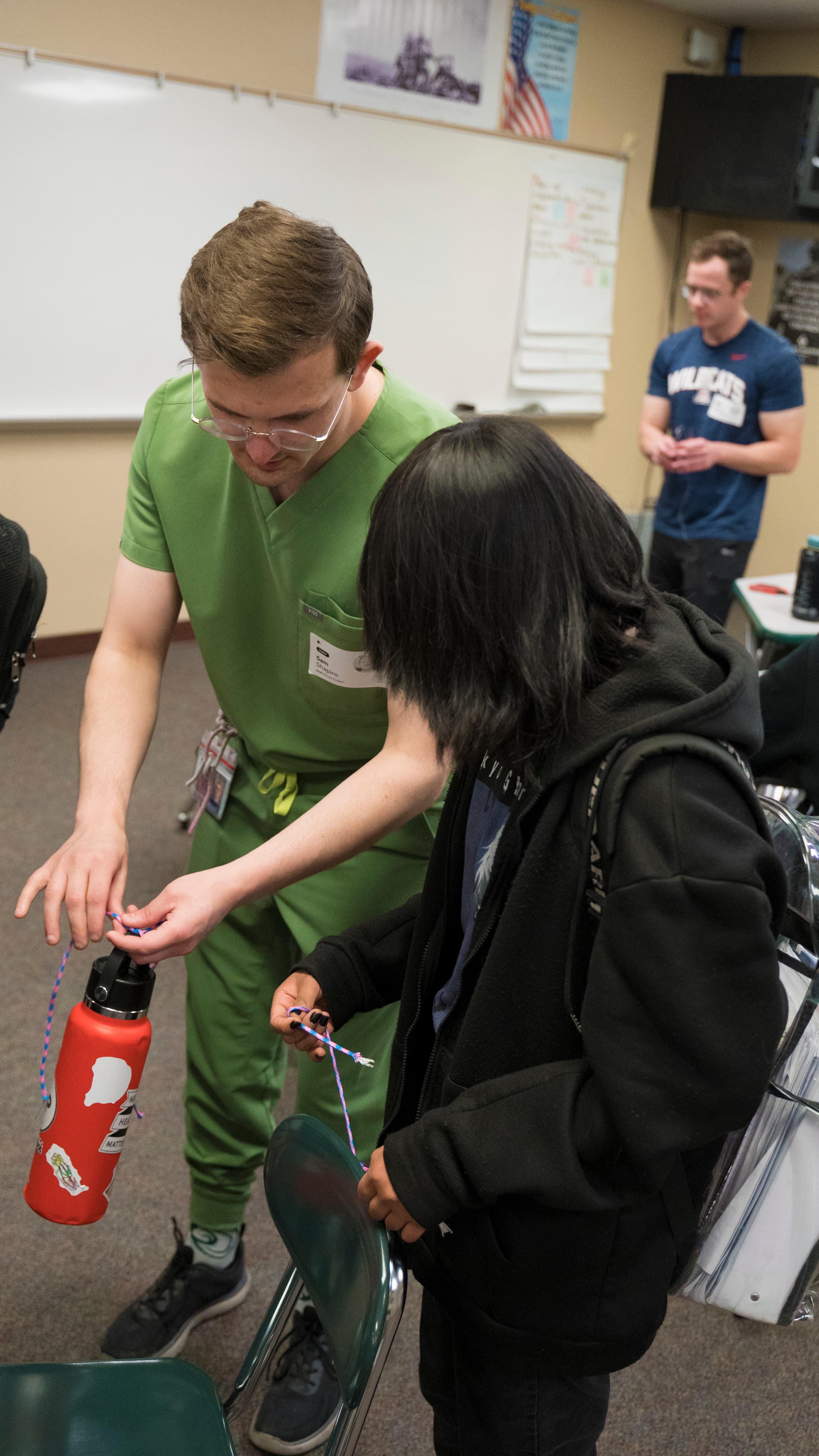 Instructor Sam teaching knot tying using a water bottle