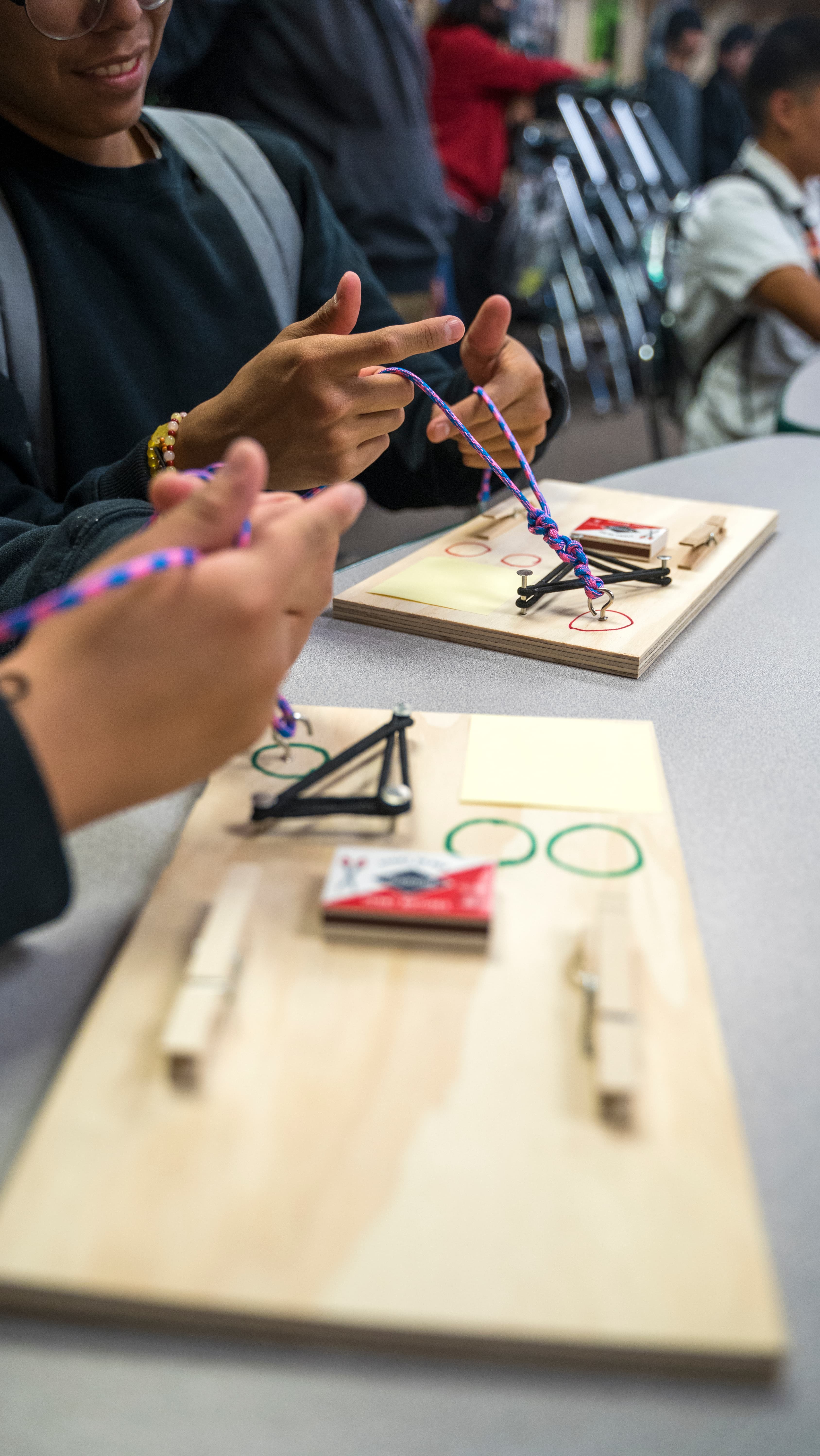 Students using their suturing kits in a classroom setting